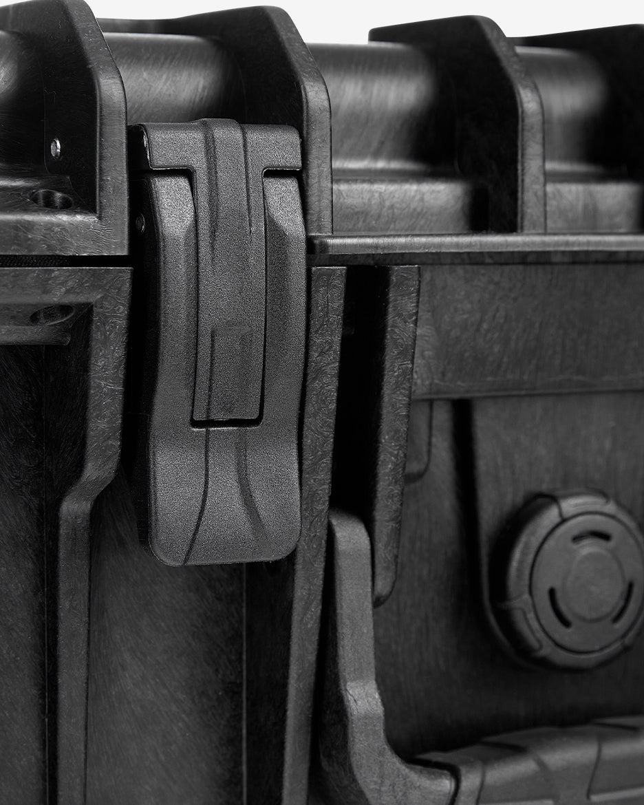 Close-up of the Card Capsule Lite latch and hinge hardware on the textured shell