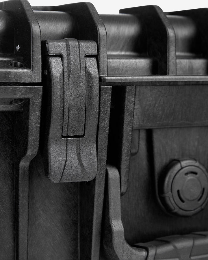 Close-up of the Card Capsule Lite latch and hinge hardware on the textured shell